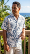 Man on an ocean lanai in the Delicate Tropical men's aloha shirt in blue